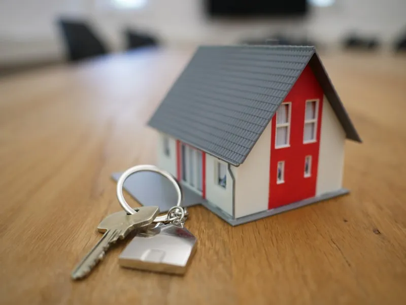 Model house and keys on a desk representing an investment property purchase